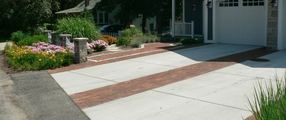 Paver driveway in Milwaukee, WI, surrounded by trees, shrubs, and flowers.