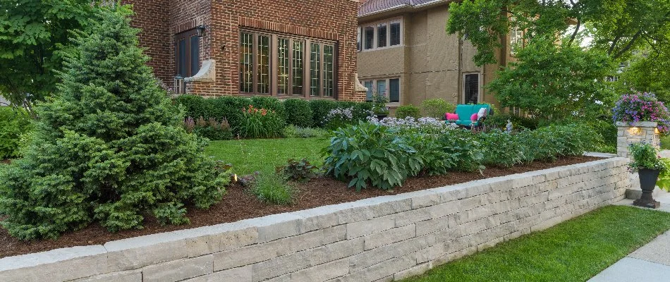 Retaining wall in Milwaukee, WI, with a raised planter bed near a lawn.