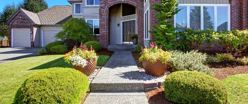 House in Milwaukee, WI, with flowers, shrubs, and a green lawn.