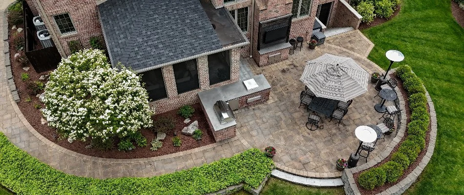 A patio, outdoor kitchen, and landscaping in a backyard in Shorewood, WI.