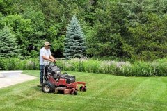 Man mows lawn with ride-on lawn mower