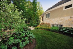 Manicured landscape by house with plants and trees