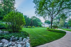 Large residential landscape with lawn and trees