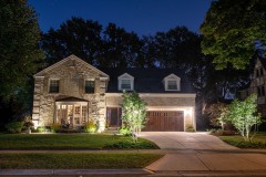 Landscape lighting in front yard of large house