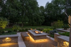 Landscape lighting by patio fireplace