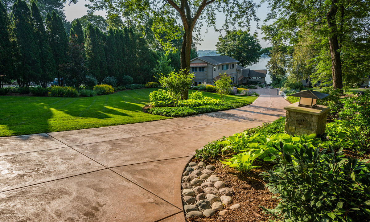 Large stone paver driveway with landscaping plants alongside