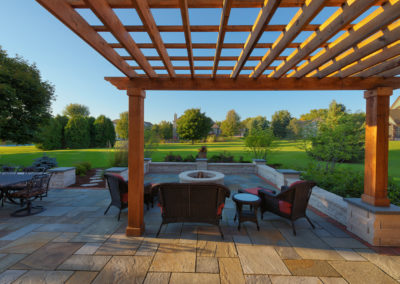 Wooden pergola and seating area looking out onto large lawn area